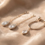 Bijoux de naissance raffinés posés avec soin sur un tissu doux, dans une ambiance lumineuse et élégante.