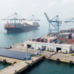 Illustration réaliste d’un port vietnamien en eau profonde avec un porte-conteneurs, des grues de quai, des conteneurs non marqués et des équipements évoquant une logistique durable.