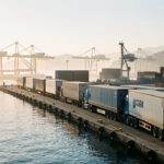 Port de Marseille au lever du jour, avec des camions et remorques de fret alignés sur le quai avant un départ vers la Corse.